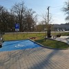 Miejsce parkingowe dla osób niepełnosprawnych na parkingu przed budyniem.